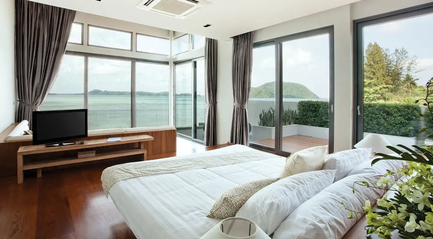 Bedroom with expansive uPVC & Aluminium sliding doors opening to a sea view terrace